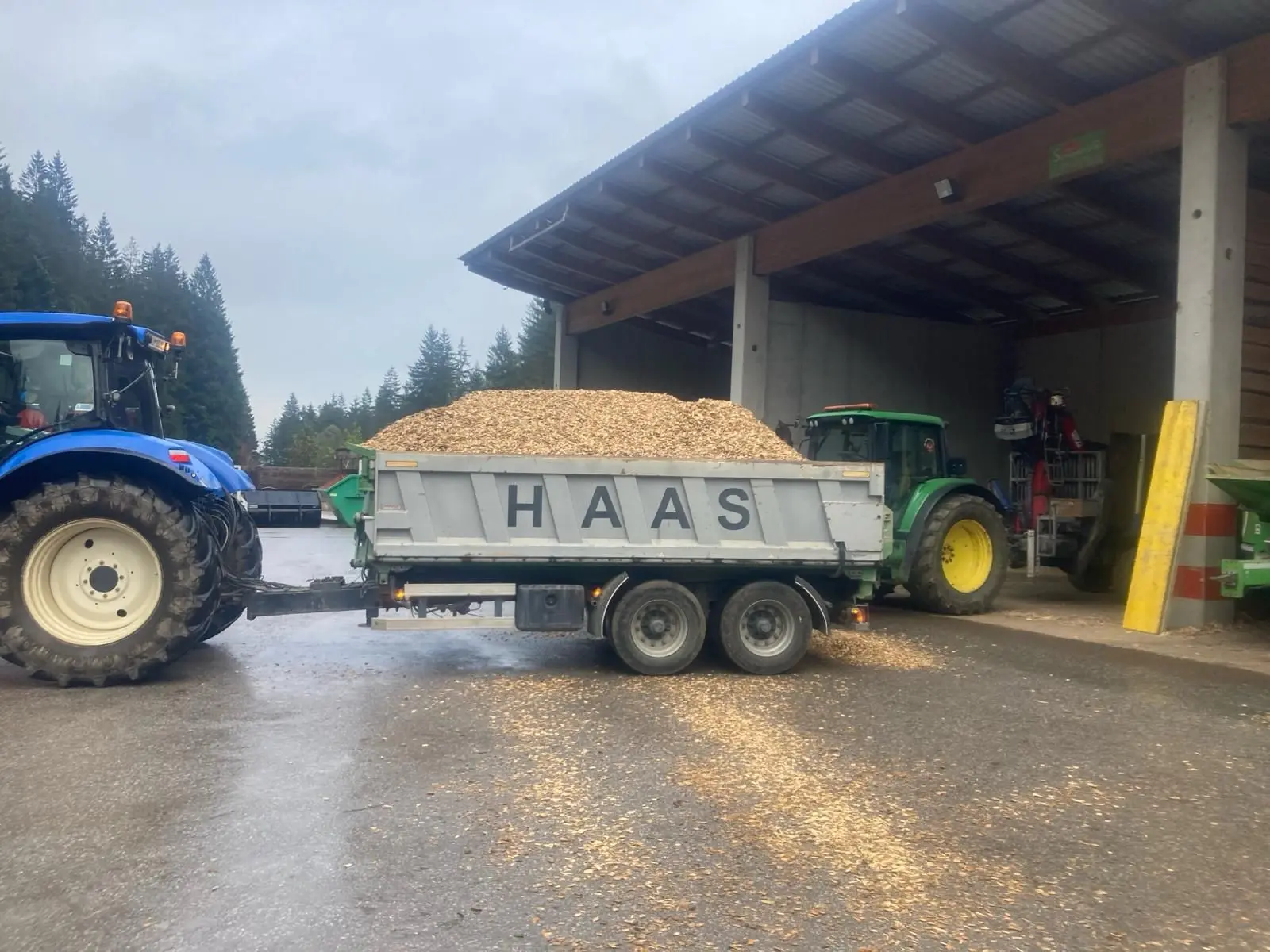 Traktor mit Haas Anhänger für Holzmaterial